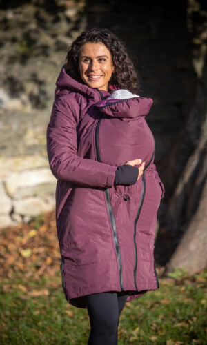 žena objímající miminko nesoucí v šátku v dlouhé zimní nosicí bundě Angel Wings v bordó barvě