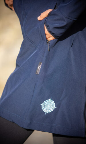 detail kapsy a loga s mandalou u dlouhého nosicího softshellového kabátu Angel Wings