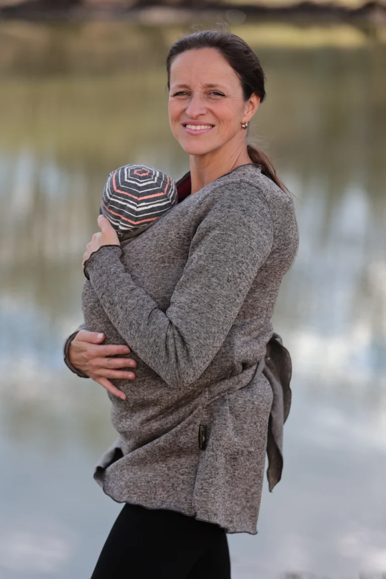 Maminka s miminkem v zavinovacím nosicím svetru Angel Wings v hnědém melíru, ideální na nošení dětí v šátku nebo nosítku.